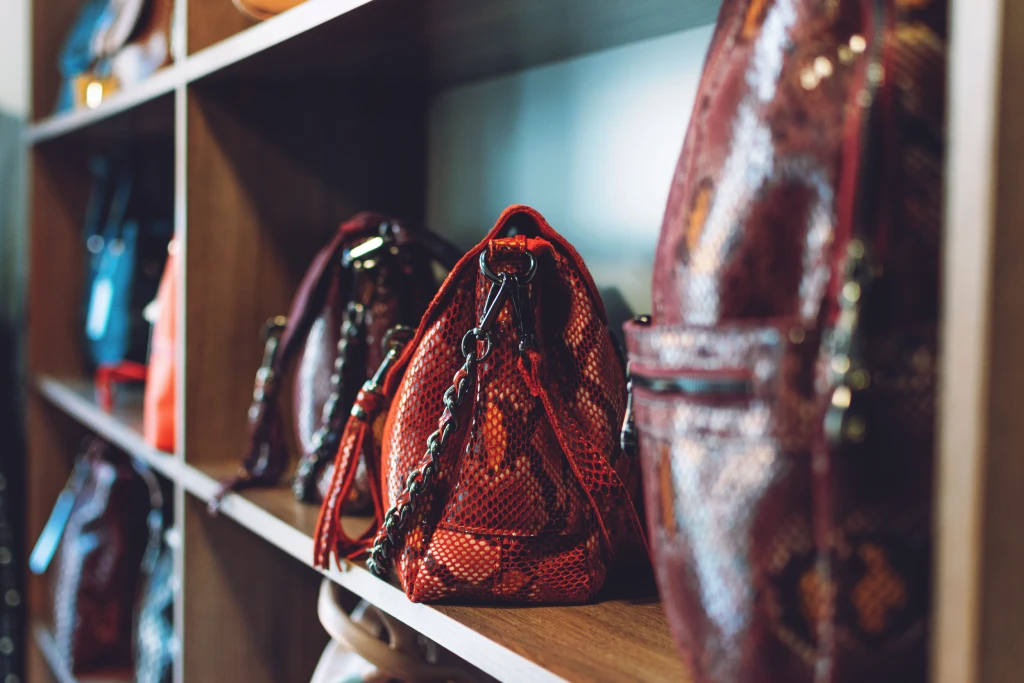 Luxuriöse Designer-Handtaschen hinter Glas in einer Boutique oder einem Schaufenster.