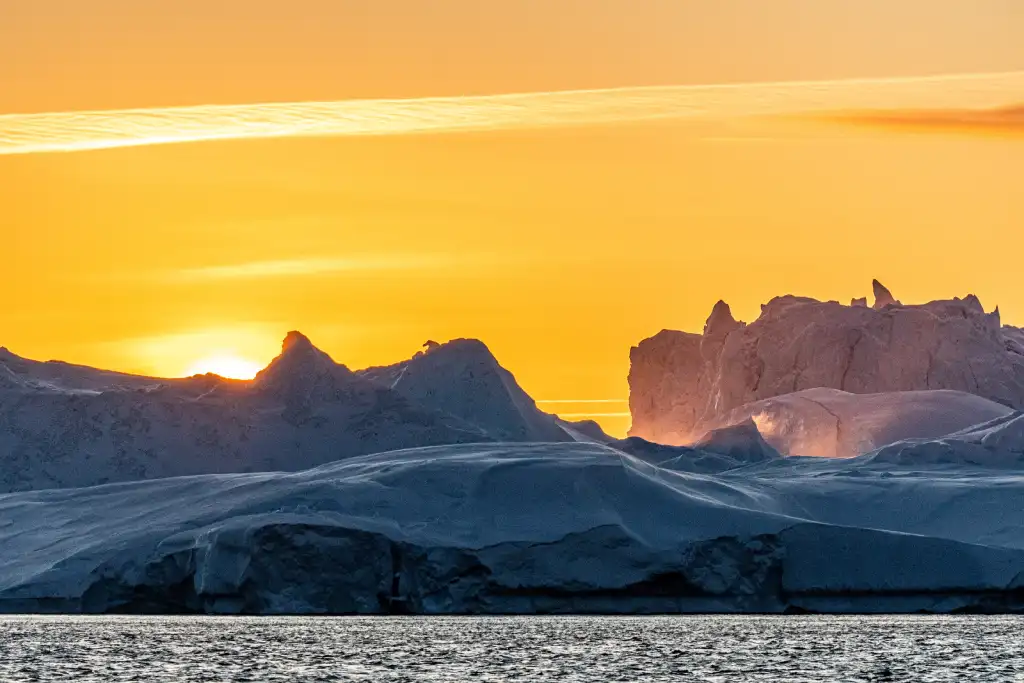 Vereiste Berglandschaft mit schroffen Gipfeln im warmen Licht eines Sonnenuntergangs.