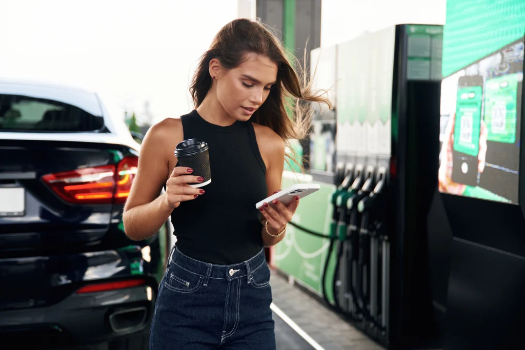 Frau prüft aktuelle Ölpreise auf dem Smartphone – Einfluss auf persönliche Finanzen | Financipation Club