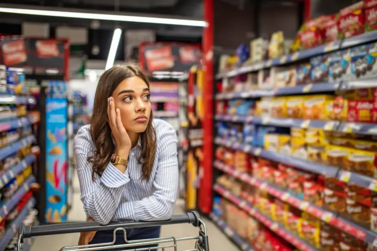 Frau beim Einkaufen im Supermarktregal – Financipation Club