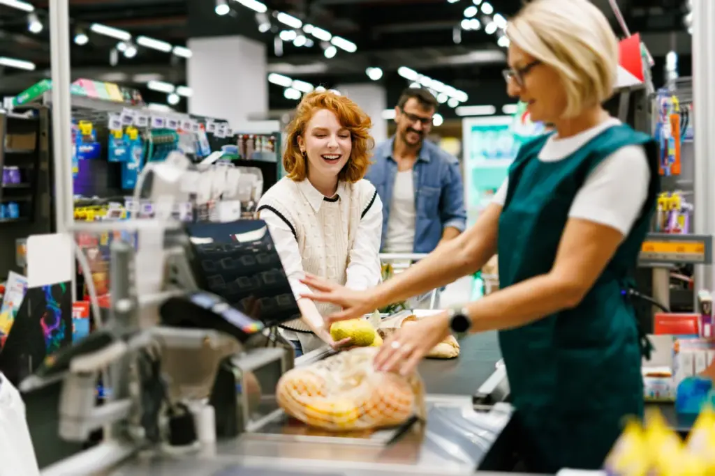 Kundin beim Bezahlen an der Supermarktkasse – Financipation Club